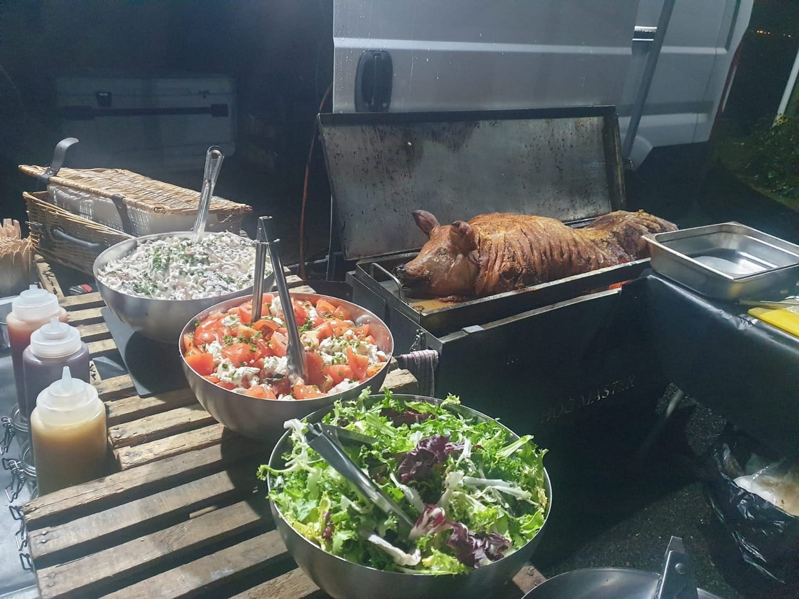 Hog roast with fresh sides at an outdoor event