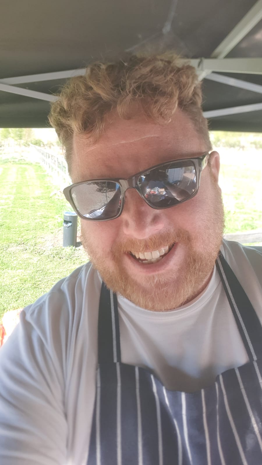 The Chef 0151 chef smiling at an outdoor catering setup