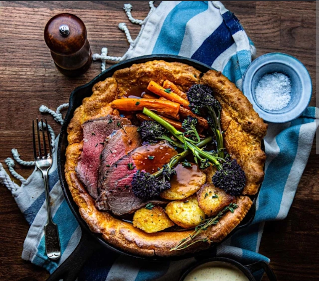 Giant Yorkshire pudding with roast beef, roast potatoes and vegetables